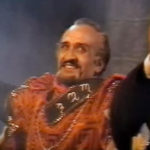 Delago as The Master delivers a rock'n'roll hail satan salute in Classic Who serial The Daemons