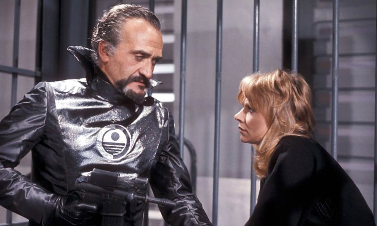 Roger Delgado in his last appearance as the master holds companion Jo Grant at gunpoint