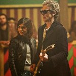 The 12th Doctor holding an electric guitar next to Clara in The Magician's Apprentice